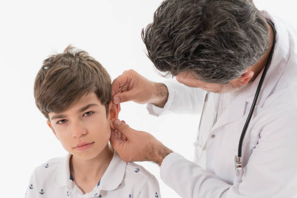 close-up of male doctor examining boy's ear - young ears imagens e fotografias de stock