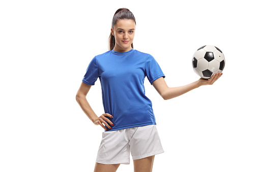Young woman soccer player holding a football isolated on white background