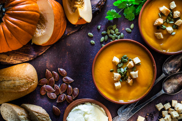 zupa dyniowa ze składnikami na rustykalnym brązowym stole. widok z góry - thanksgiving vegetarian food pumpkin soup zdjęcia i obrazy z banku zdjęć