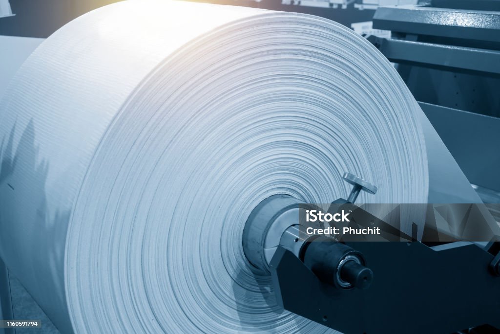 The roll of material for plastic bag manufacturing process. The roll of material for plastic bag manufacturing process. The plastic bag in the roll. Plastic Stock Photo