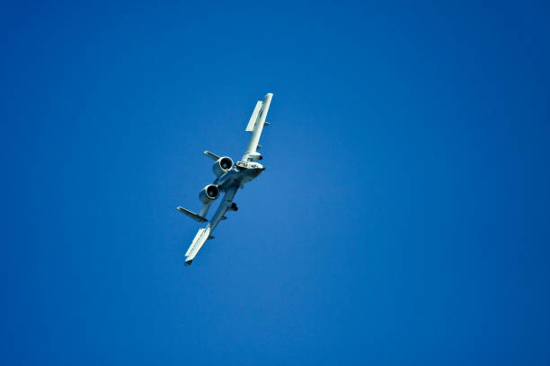 A-10 Warthog flying at a distant Tuscaloosa AL USA - October 13, 2018 : Taken this picture at a public event of the A-10 Warthog flying in front of spectators and general public. Tried to take full profile of the aircraft from behind when it is taking a full circle to come back again. A-10 aerodynamic allows it to take a sharp turn at slow air speed against the overcast sky. A-10 can be identified from a distant due to its placement of the engine outside the main fuselage of the aircraft. a10 warthog stock pictures, royalty-free photos & images