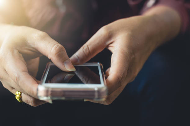 istock hipster woman using hands touching and typing on mobile phone screen search internet online working or social communication with digital technology app device in coffee shop indoor vintage lifestyle. 1160594866