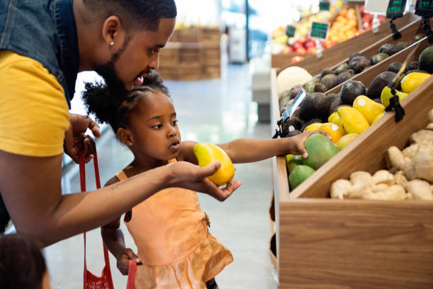 father and daughter in zero waste oriented fruit and grocery store. - environment homegrown produce canada north america imagens e fotografias de stock