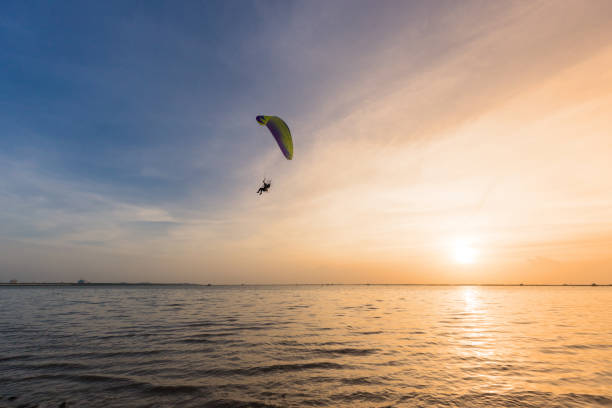 istock Silhouette of Paramotors flying to sky on sunset. 1160598857