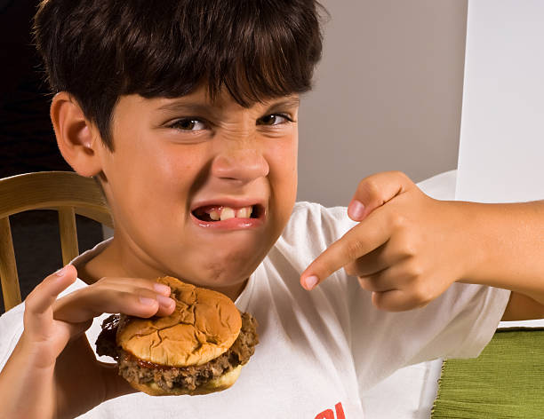 I hate junk food child pointing a hamburger expressing dislike brat burger stock pictures, royalty-free photos & images