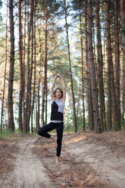 istock Woman practicing yoga alone in the forest outdoor 1160602600