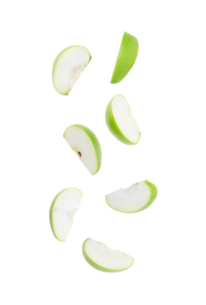 cortar la manzana verde madura cayendo aislada sobre el fondo blanco con el trazado de recorte - apple fotografías e imágenes de stock
