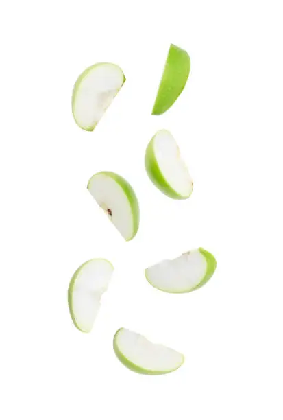 Photo of Slice ripe green apple falling isolated on white background with clipping path