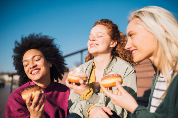 istock Girls eating donuts 1160603173