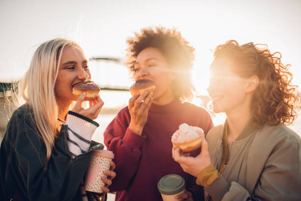 istock Girls eating donuts 1160603930
