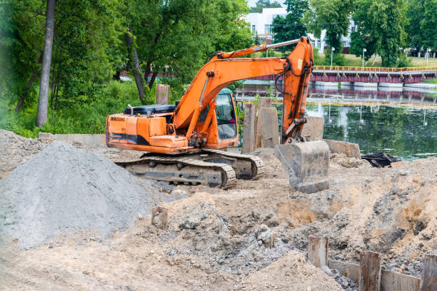 istock Excavator performs excavation work on the construction site. Yellow tractor digs the ground 1160604362
