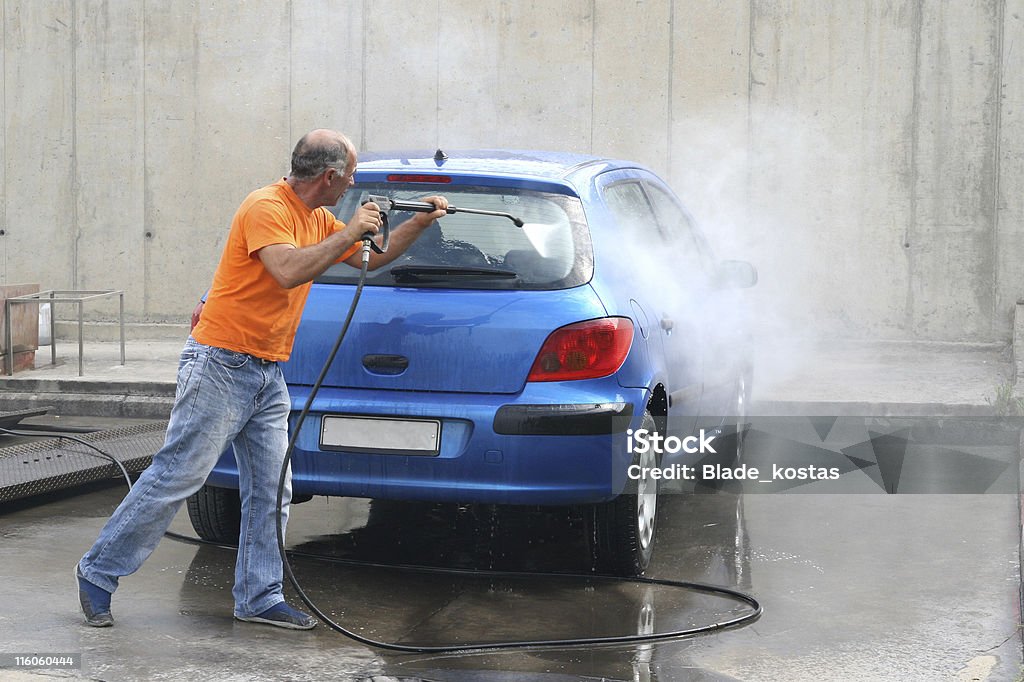 car wash with water pressure men wash a european car with water Adult Stock Photo