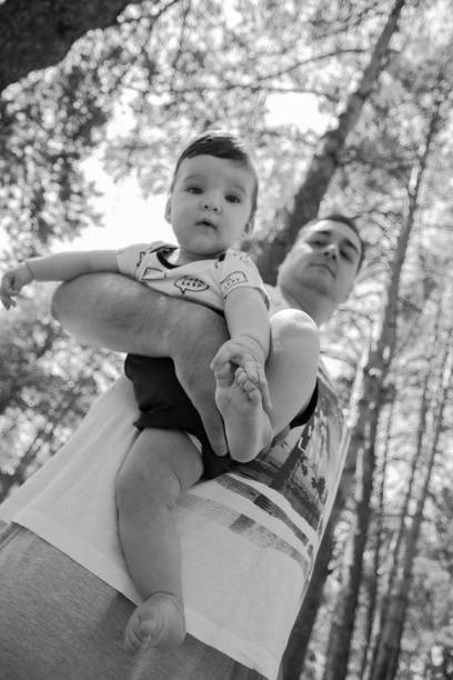 низкий угол зрения милый ребенок в руках отцов - babies and children cheerful low angle view vertical стоковые фото и изображения