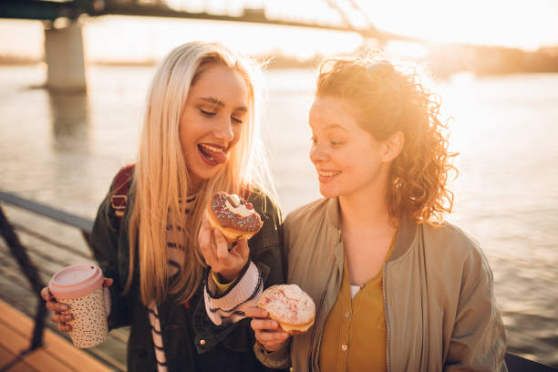 istock Girls eating donuts 1160605249