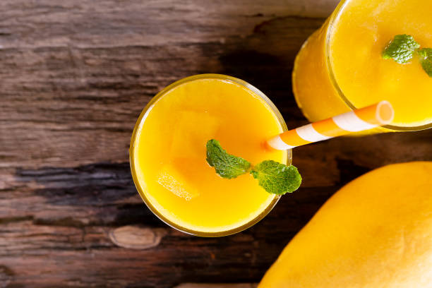 istock Mango smoothies juice orange fruit juice milkshake blend beverage healthy high protein the taste yummy in glass episode drink morning on wood background from top view. 1160605360