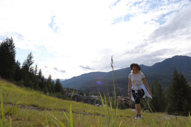 istock Mature woman hikes up mountain meadow 1160605863