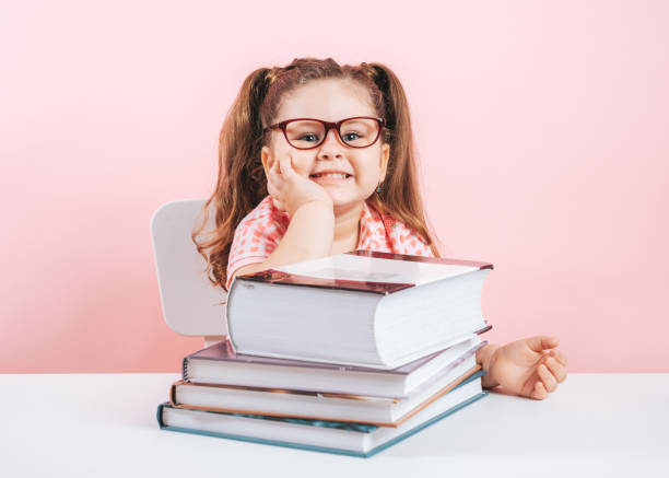 istock smiling blond little cute girl studying on books 1160606501