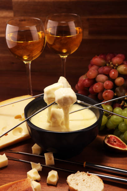 istock Gourmet Swiss fondue dinner on a winter evening with assorted cheeses on a board alongside a heated pot of cheese fondue 1160608046