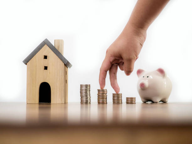 istock Fingers hand step forward on stack of coins with piggy bank and model house on white space background concept business finance growing idea 1160608279