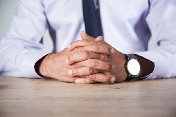 istock man cross fingers on desk 1160609289