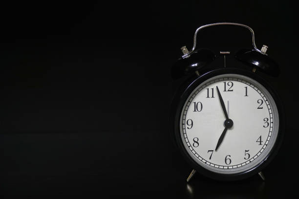 istock Classic mechanical alarm clock on dark background 1160611922