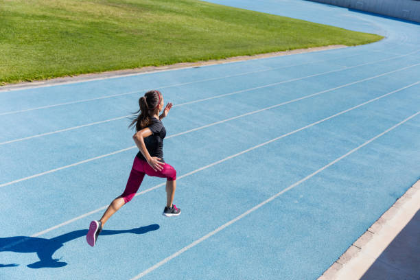 coureur sprintant vers le succès sur la piste de course - track and field athlete women vitality speed photos et images de collection