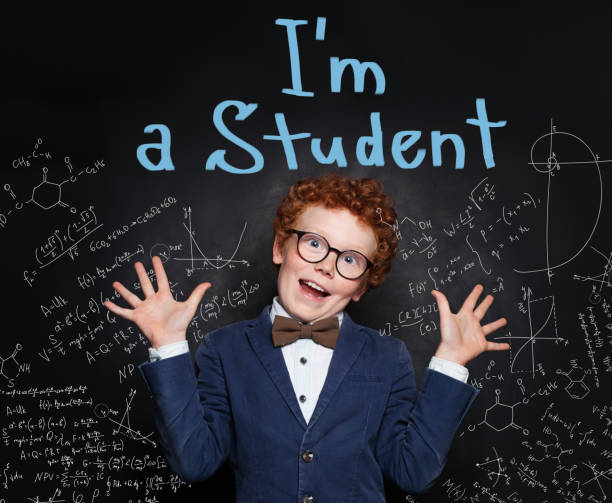 istock Little kid school student in classroom on chalkboard background 1160615814
