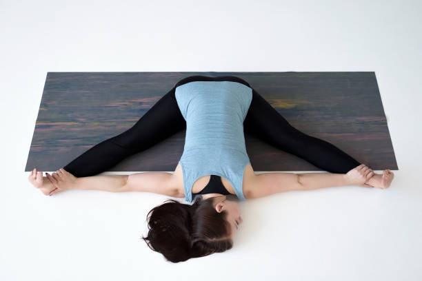 istock Young woman practicing yoga, doing Kurmasana, Tortoise posture, Turtle Pose 1160620816