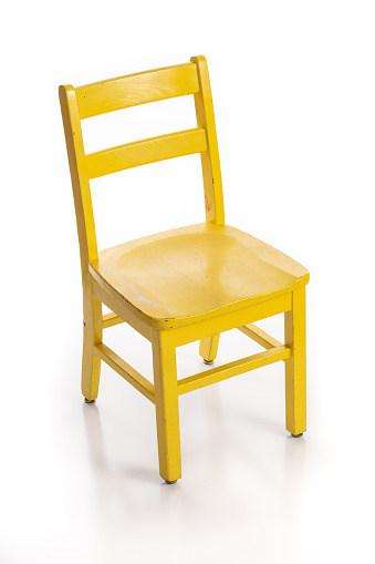 Wooden child chair painted yellow isolated on a white background.