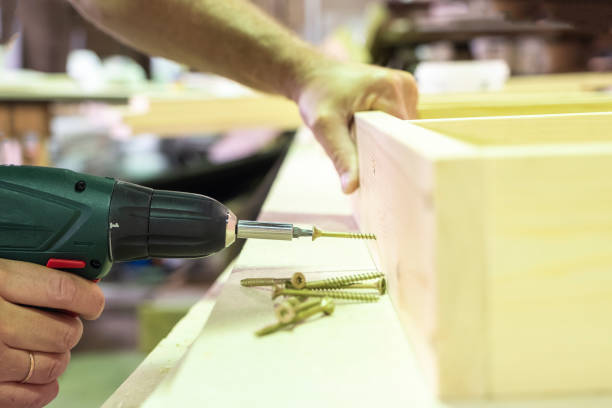istock A carpenter drills and tightens the screws with a cordless drill. Work in a carpentry workshop with a wooden structure. 1160621408