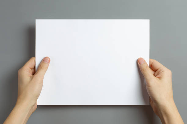 istock Hands holding a sheet of white paper 1160623569