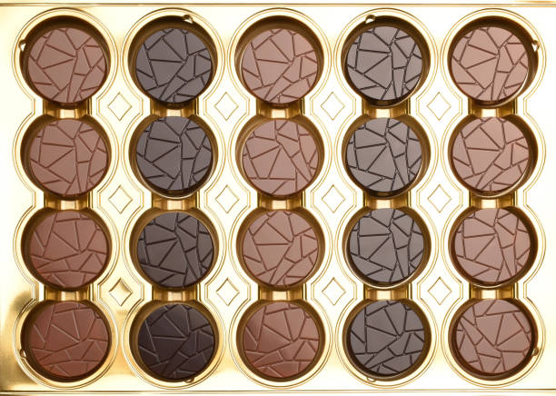 Box of chocolate candies in the shape of sea shells on a white background. Top view