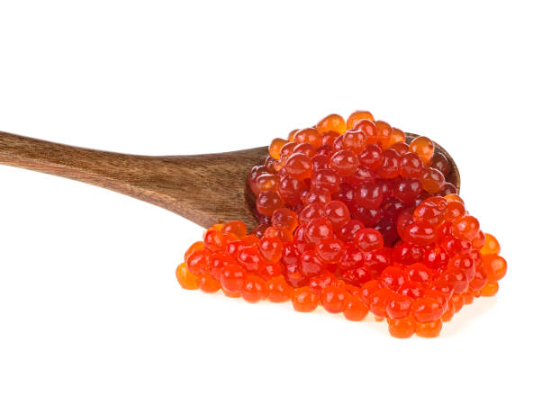 istock Red salted caviar with wooden spoon on white background 1160625941