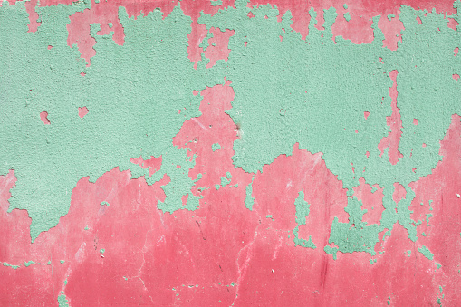 Peeled green plaster on an old wall of pink plaster. Great for design and texture background