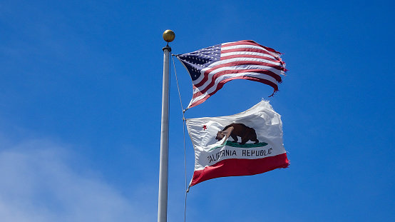Blue sky of flags USA and CALIFORNIA