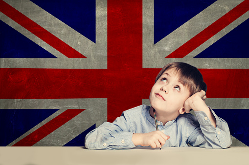 English concept with smart kid student against the UK flag background