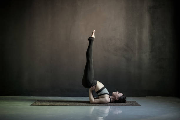 istock woman practicing yoga, standing in Viparita Karani exercise 1160629282