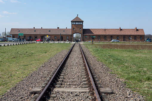 the Auschwitz-Birkenau concentration camp, located in Poland in Central Europe.  Railroad tracks lead to the main entrance building.