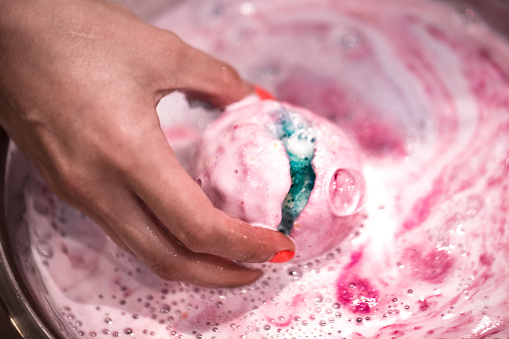 Bright natural fizzy bath bomb dissolves in his hands. The concept of natural body care
