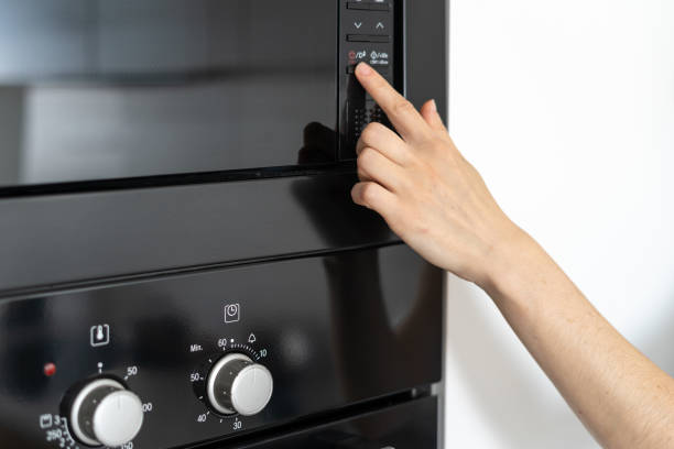istock Woman holding hand on black microwave button 1160633920