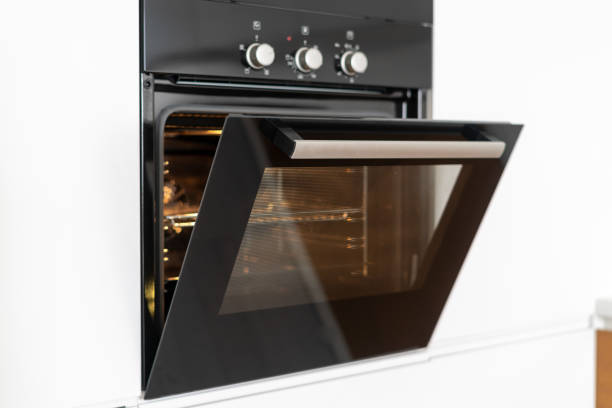 istock Modern built in oven with open glass door on white kitchen 1160634008