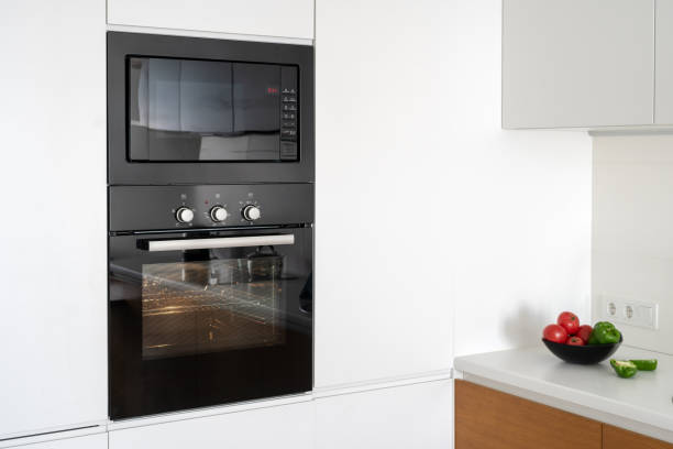 istock Modern built in oven with closed glass door on white kitchen 1160634594