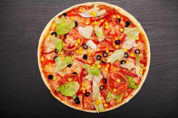 istock Tasty pizza with various flavored ingredients on a dark background 1160634656