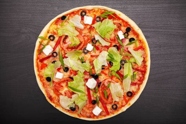 istock Tasty pizza with various flavored ingredients on a dark background 1160634678