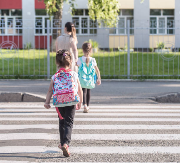 istock Back to school education concept with girl kids, elementary students, carrying backpacks going to class 1160634748