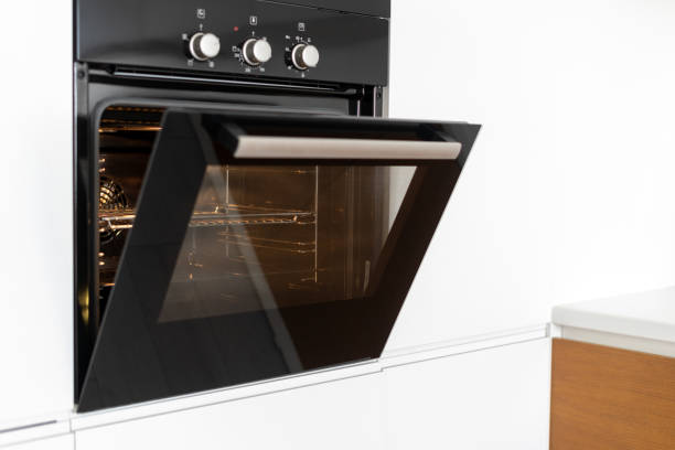 istock Modern built in oven with open glass door on white kitchen 1160634795