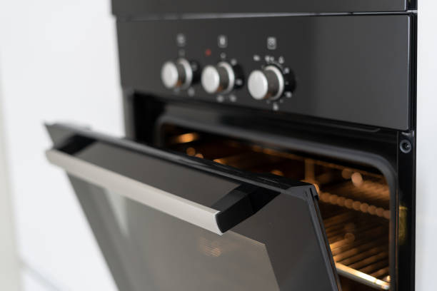 istock Modern built in oven with open glass door on white kitchen 1160634796