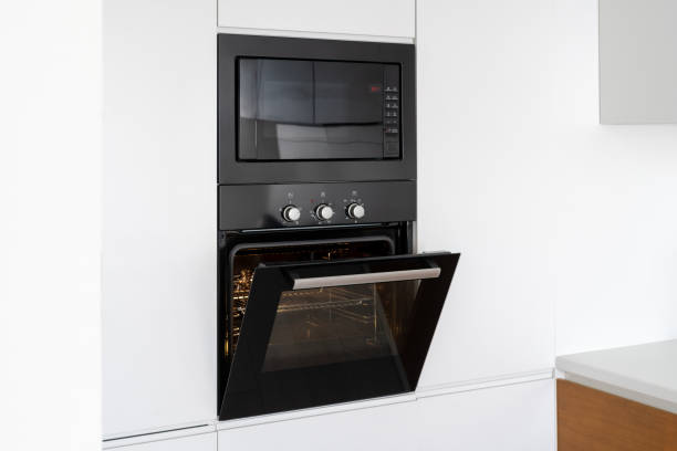 istock Modern built in oven with open glass door on white kitchen 1160634822