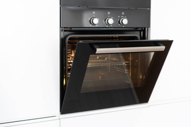 istock Modern built in oven with open glass door on white kitchen 1160634857