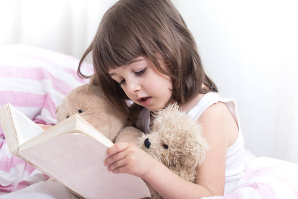 istock Cute little girl smiling while lying in a cozy white bed 1160635214